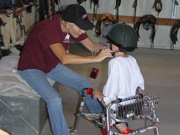 volunteer helping young student with helmet