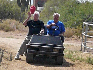 two male volunteers driving golf cart