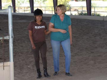 volunteer guiding blind student out of arena